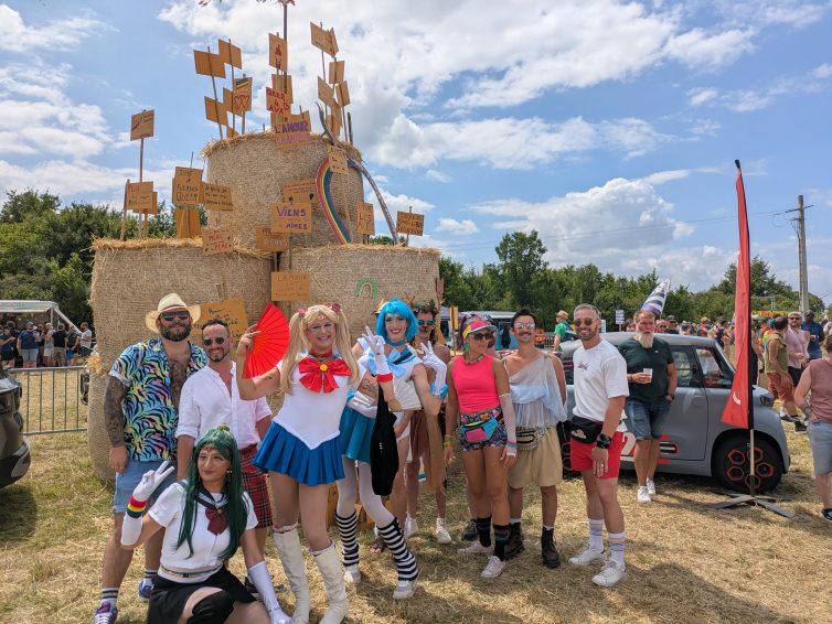 Des participants aux Fiertés rurales posent devant les bottes de pailles