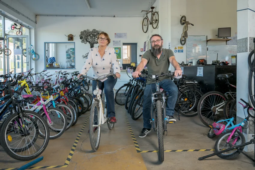 La présidente Agnès Bazelaire-Haudecoeur et le directeur Romain Discrit posent devant des vélos rénovés, prêts à repartir pour une seconde vie.